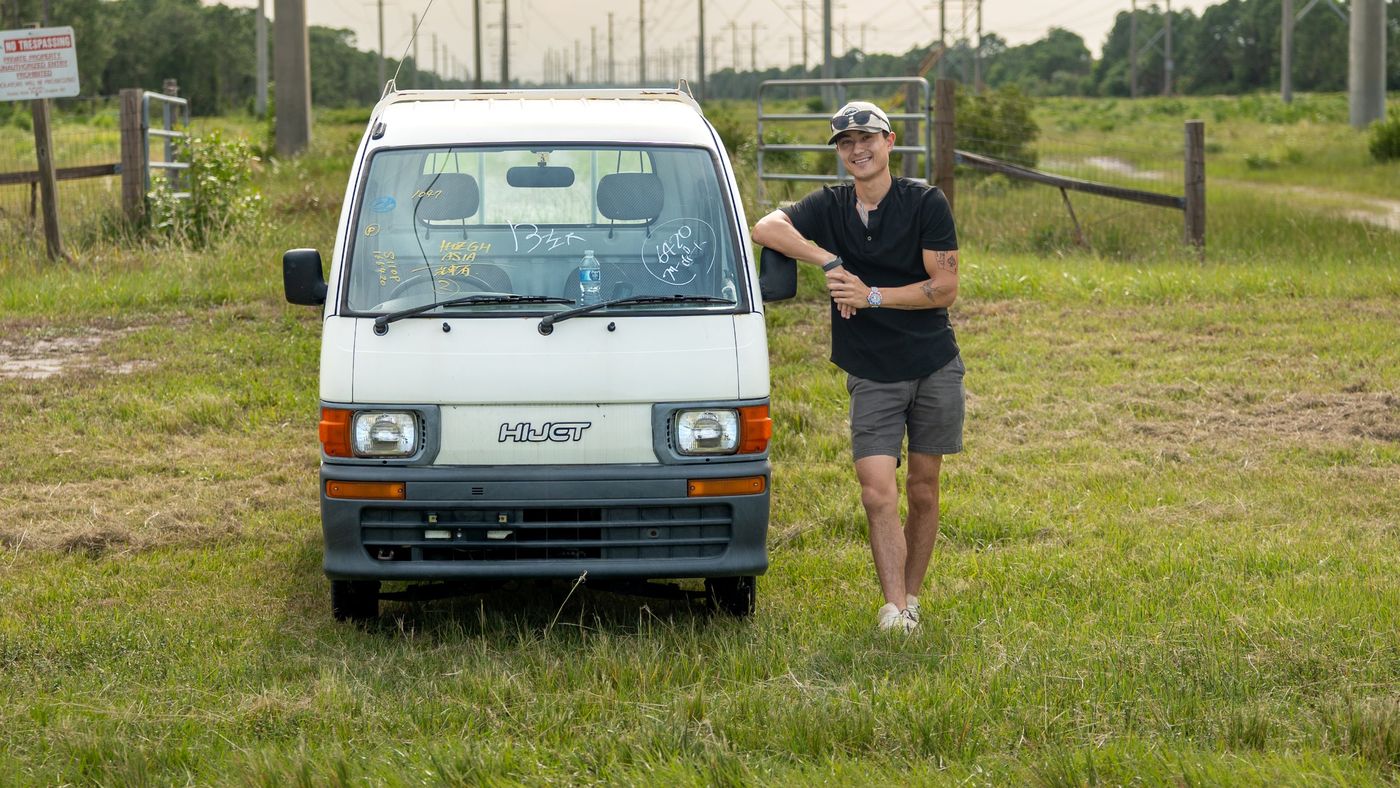 Zach with his white 1999 Daihatsu Hijet in a field